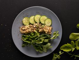 Overhead view of healthy food in plate on black background, copy space
